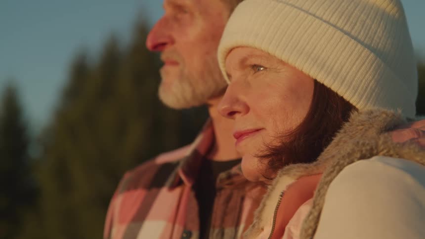 Man and woman smile as they stand close together outdoors