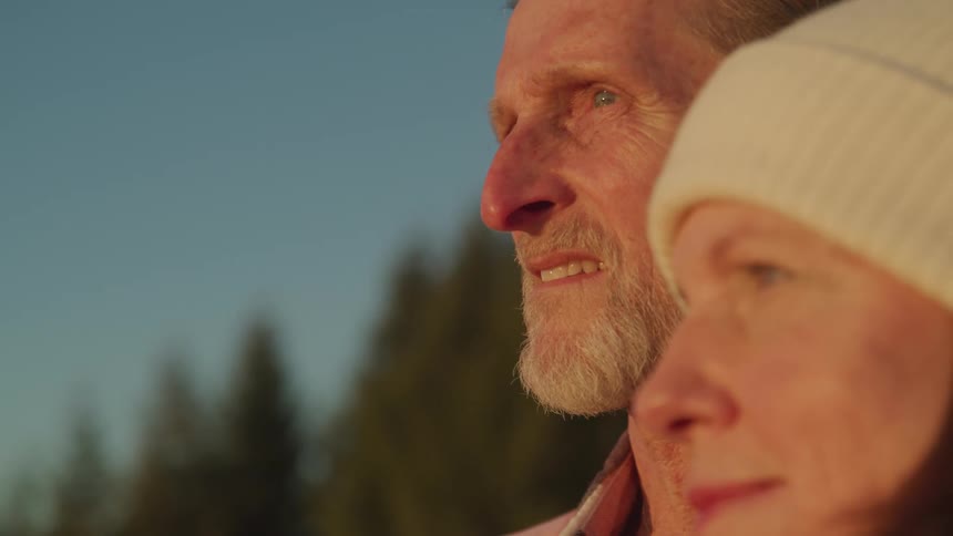 A man and woman are standing outdoors at sunset