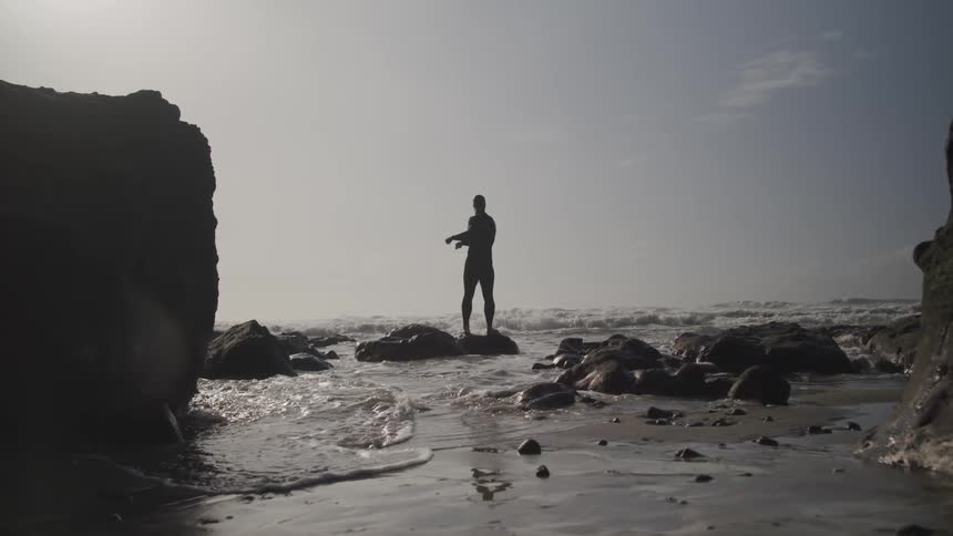 A man is stretching outdoors by the beach
