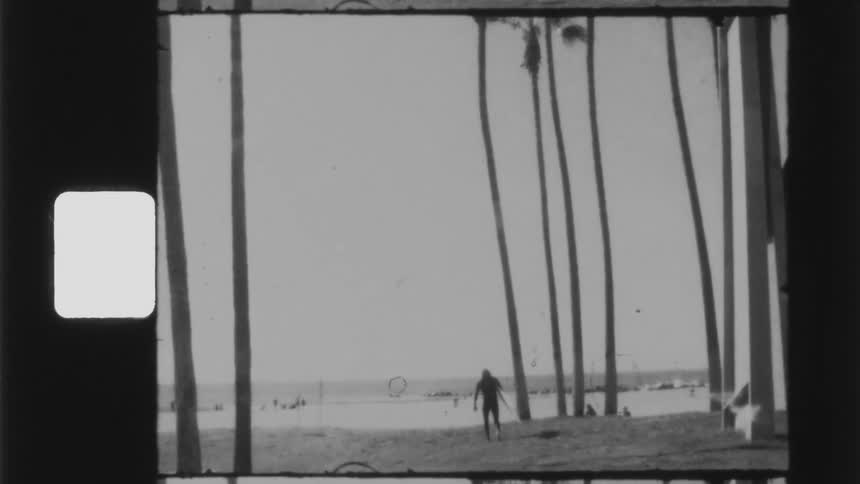 A surfer with a surfboard walking on a beach in the daytime