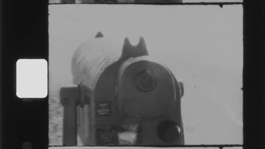 A telescope covered in snow with a person standing in the background