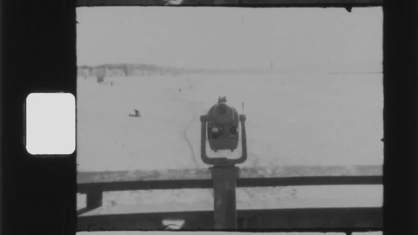 A telescope overlooking a beach in the daytime