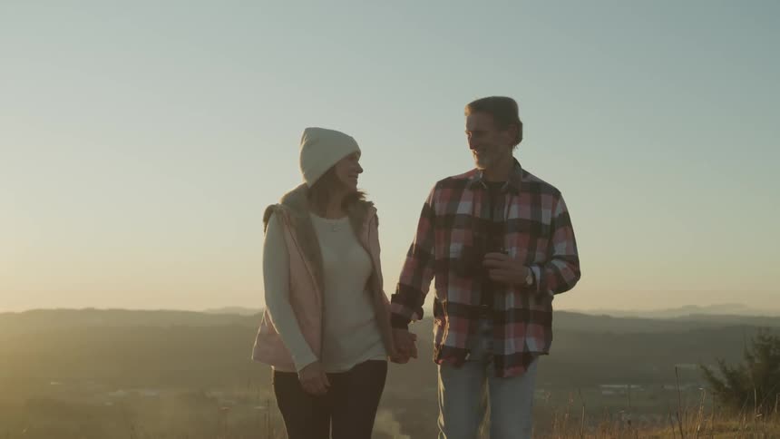 A husband and wife hike on the mountain