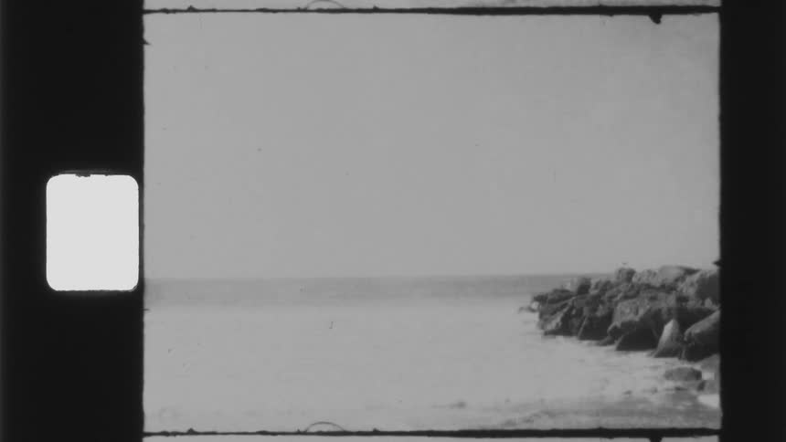 A vintage film of waves hitting rocks on the shore
