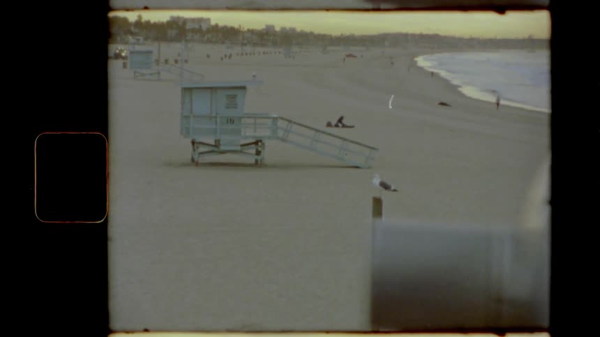 Lifeguard station on the sand of a beach next to the ocean at sunset caught on film