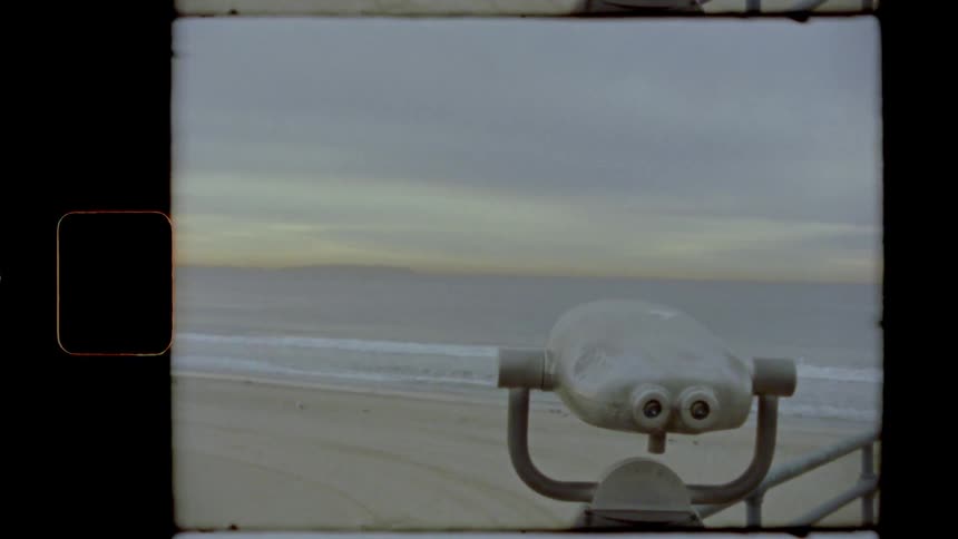 Binoculars on a pier looking at the beach at sunset caught on film