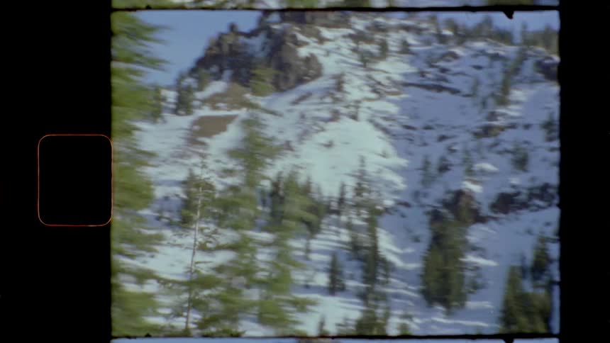 Vintage film of mountains and trees covered in snow