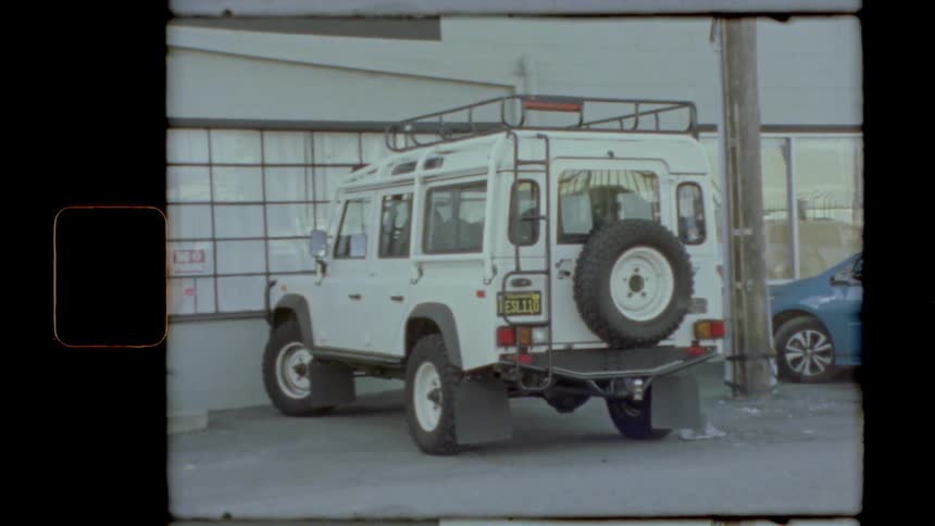An off road vehicle parked outside of a building during the day