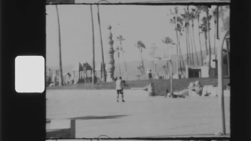 A man dribbles and shoots a basketball at a basketball goal on an outdoor basketball court