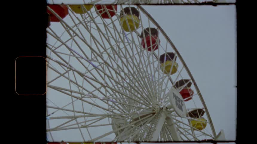 Red and yellow gondolas on a large ferris wheel
