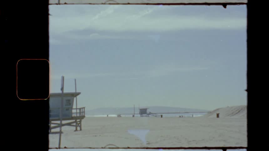 Lifeguard towers on a sandy beach under a sunny sky