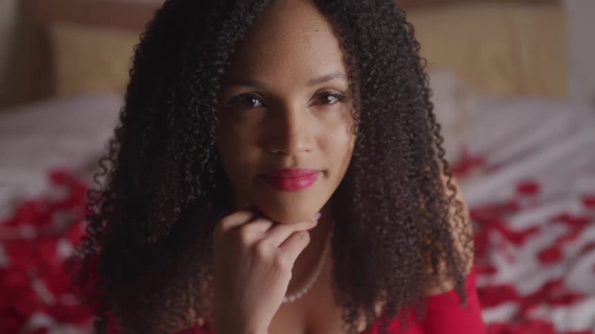 A woman is sitting on a bed indoors