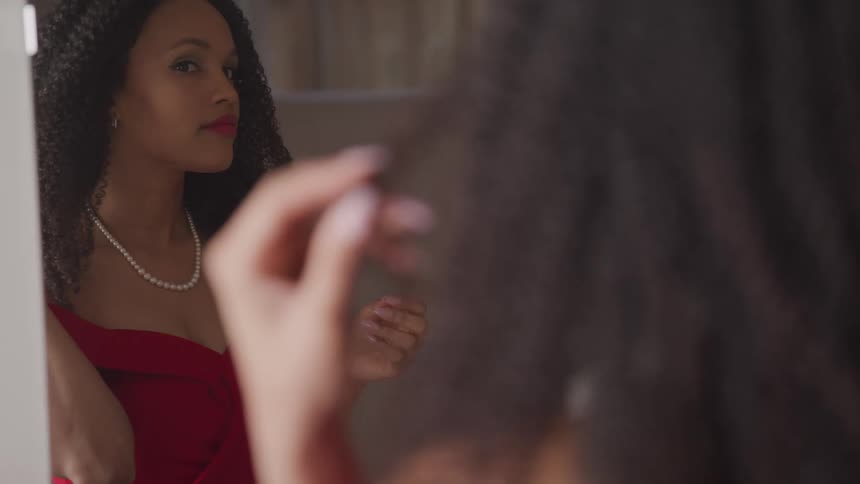 A woman is looking at herself in the mirror