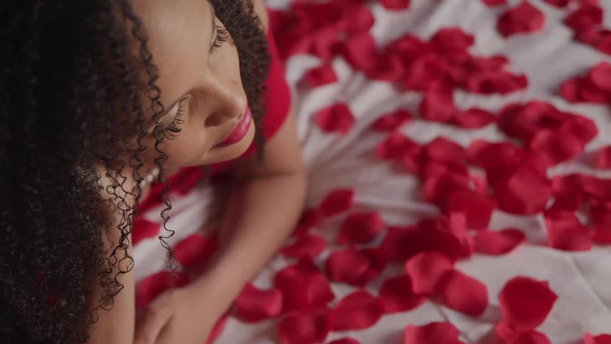 A woman all dressed up lying on a bed of roses