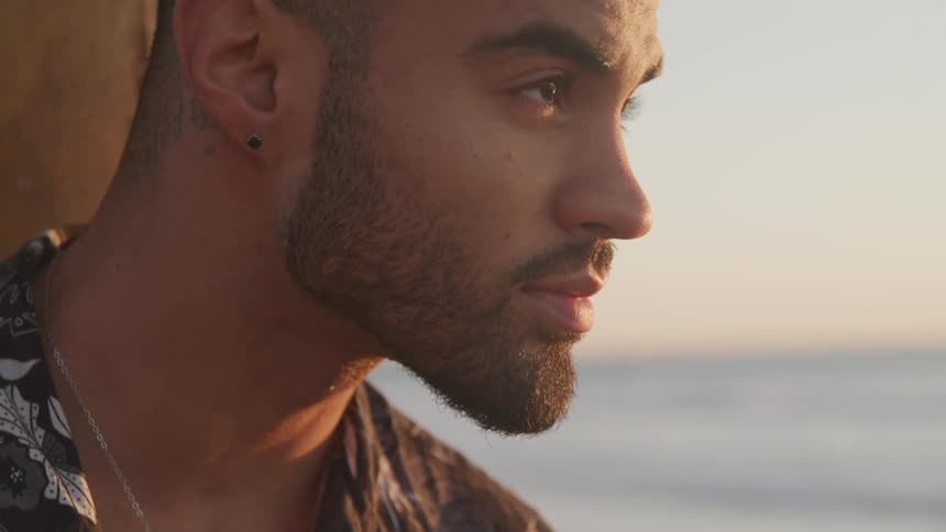 A man is standing outdoors at dusk