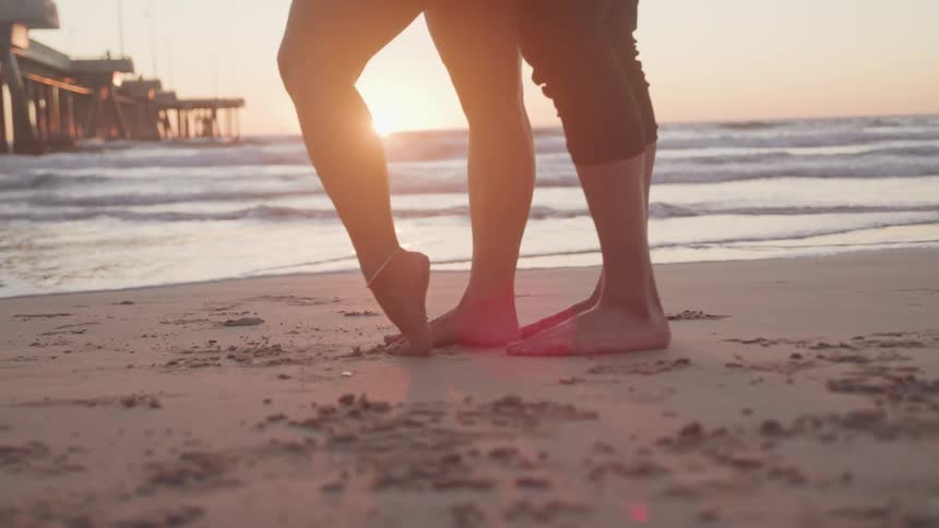 A couple standing on the beach near each other