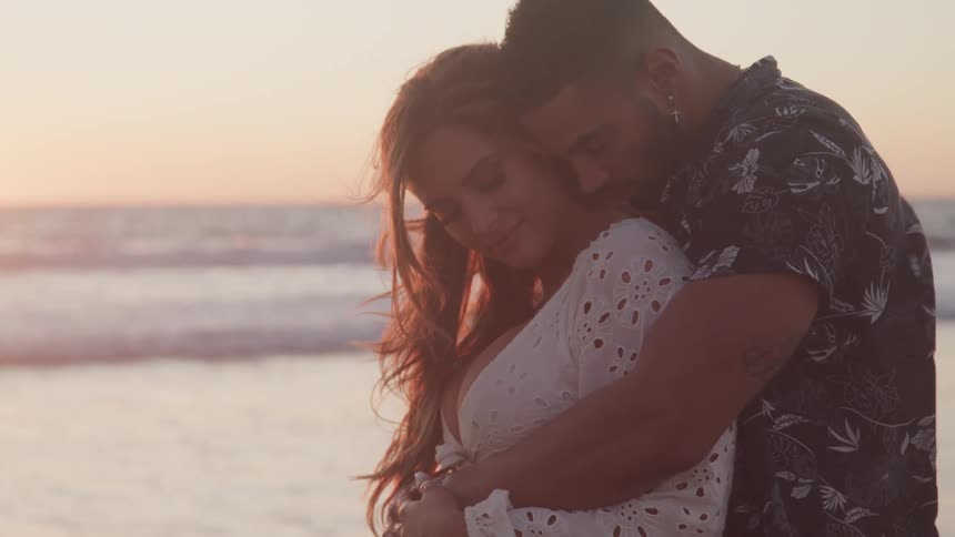 A man and woman hugging on the beach