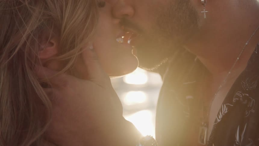 A man and woman kissing outside