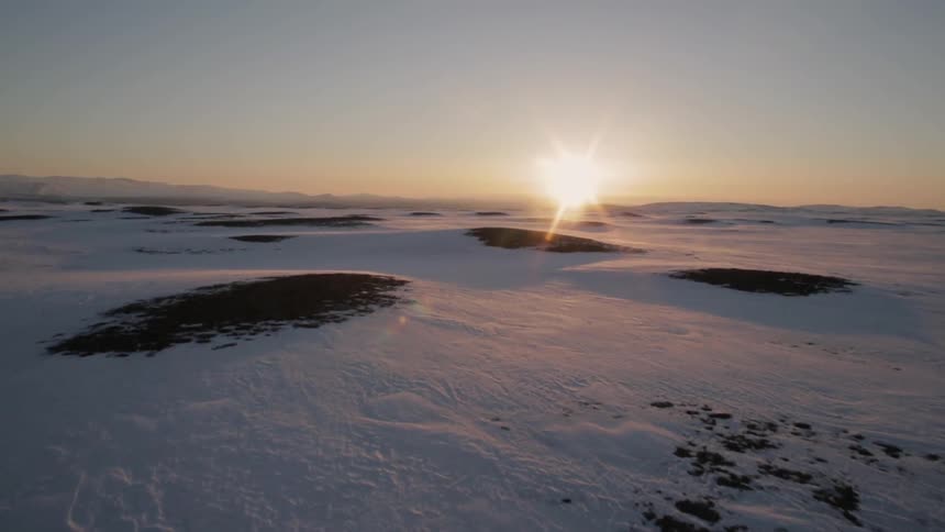 Moving fast over a snowy field at sunset