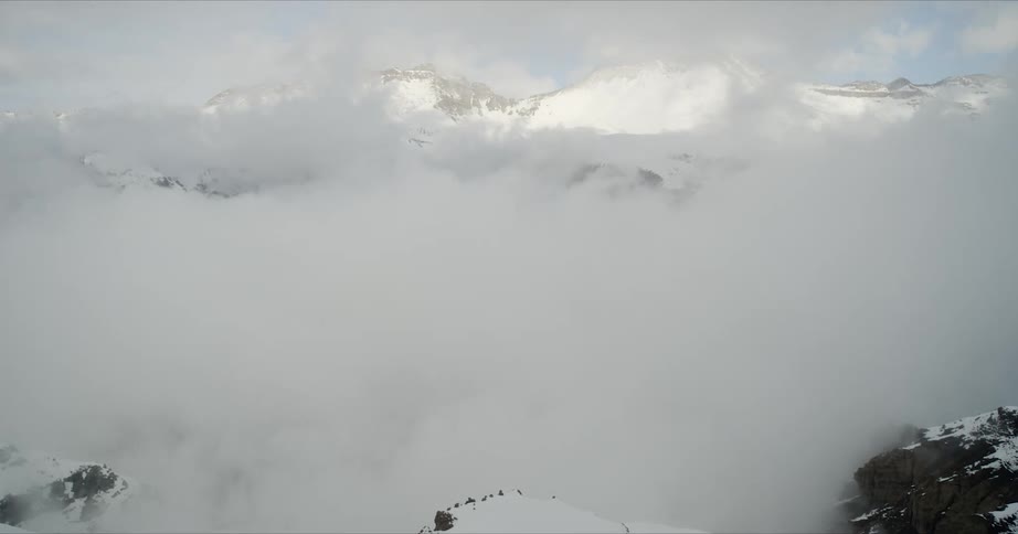 A snowy valley filled with clouds