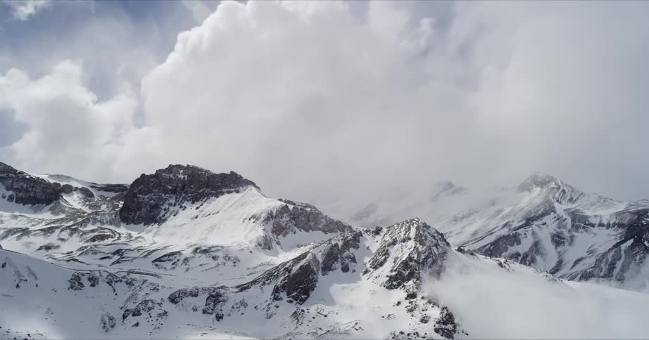 Time lapse of clouds moving over a snow covered mountain range