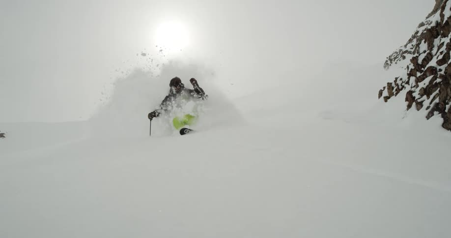 A skier spray deep powder onto the camera