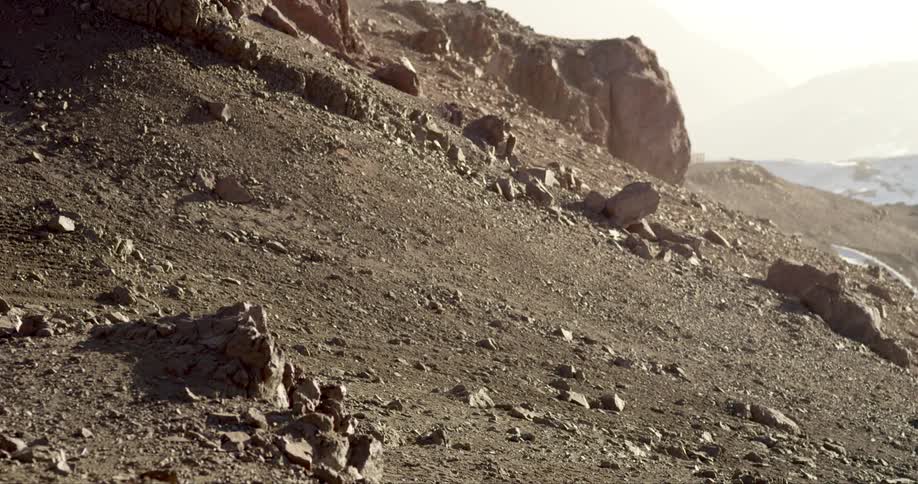A rocky slope with blowing dust