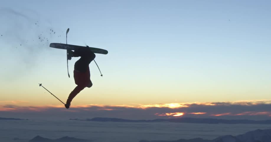A skier flips above the setting sun