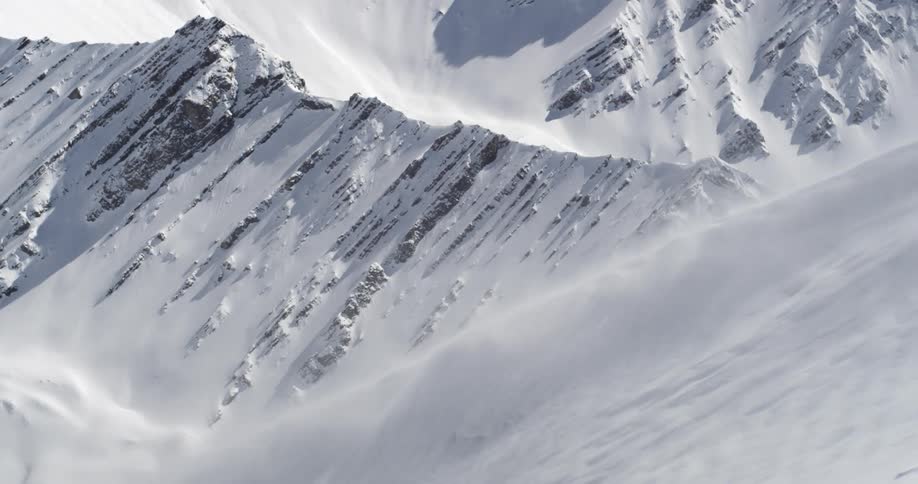 Wind blowing over snow covered mountains on a winter day