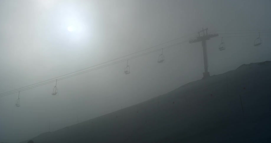 A chair lift in thick mist
