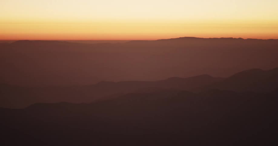 The sky is red above the mist covered mountains