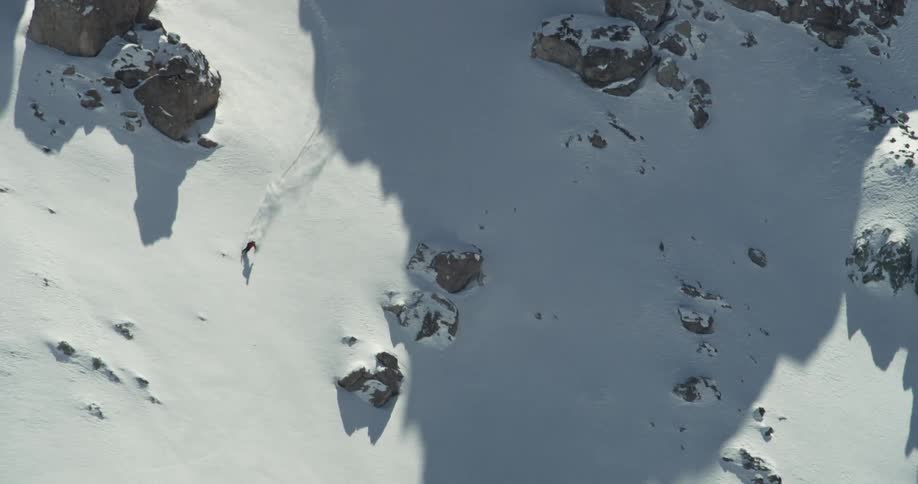 A lone skier flies through a rocky field