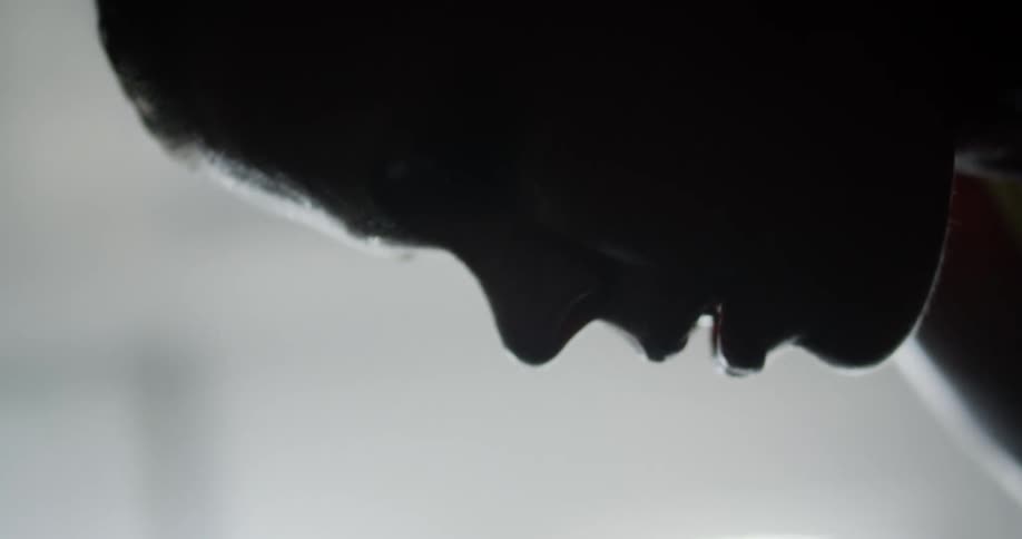Man taking a break after workout in a gym is silhouetted