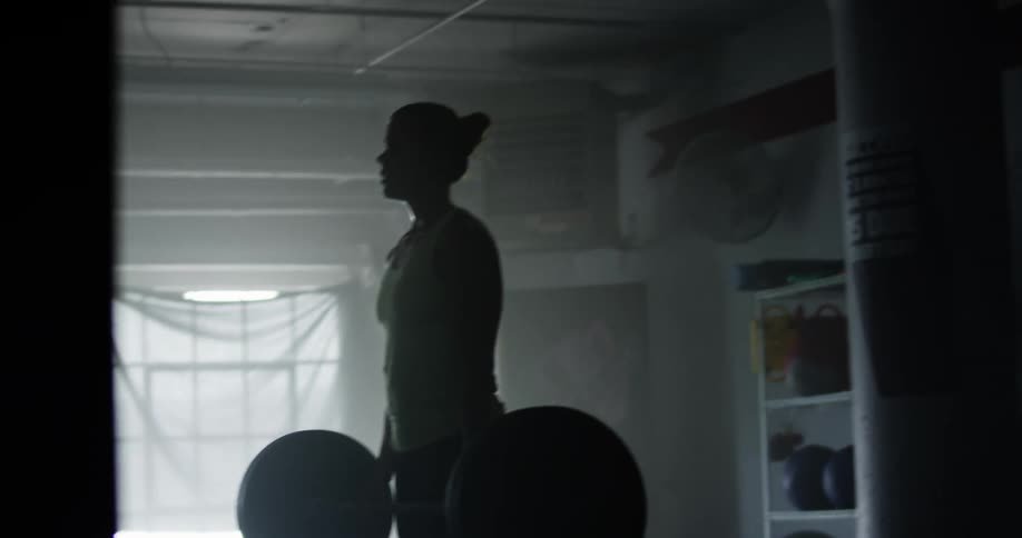 A woman is lifting weights indoors