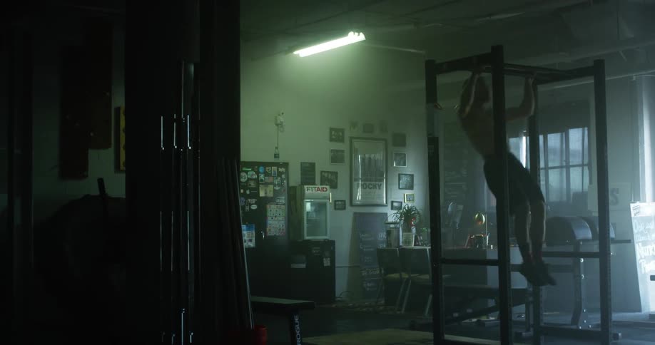 A man is doing pull ups in the gym