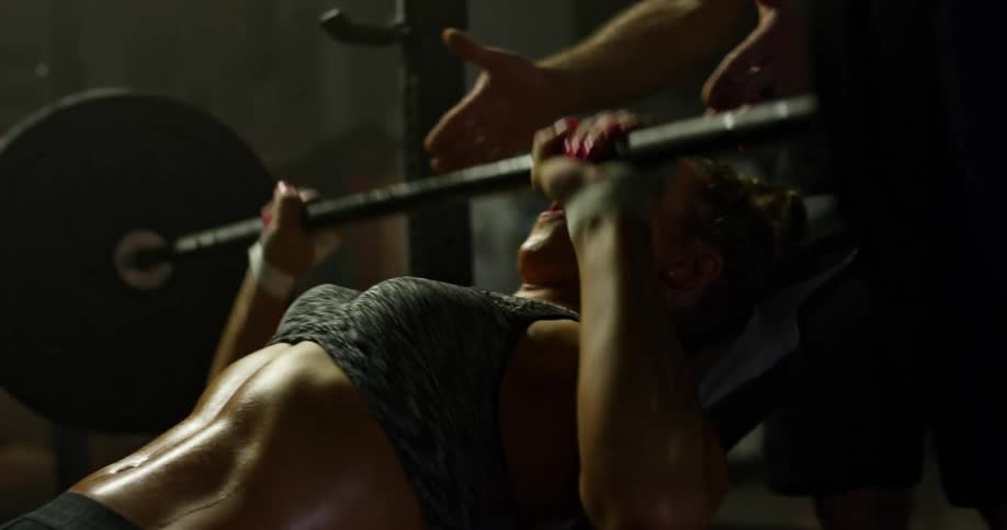 A man and woman are lifting weights in a room
