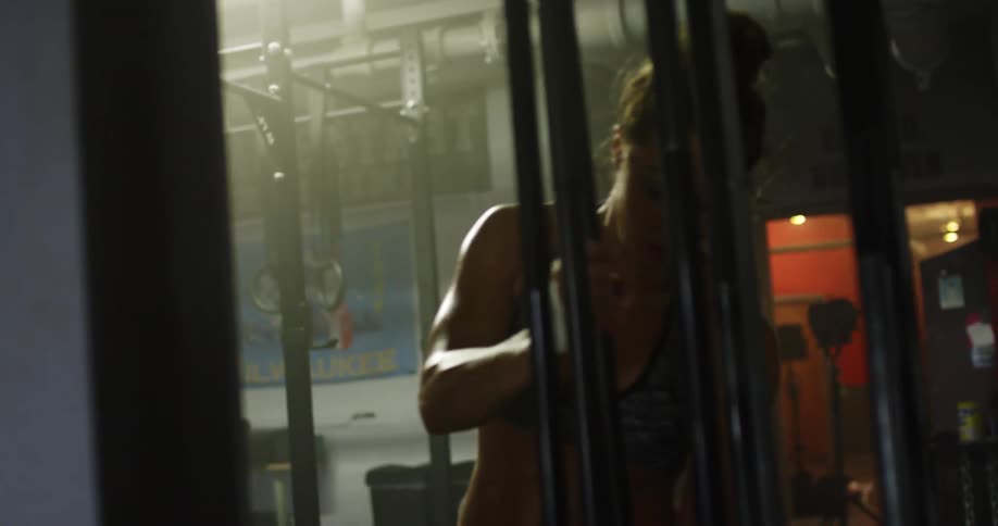 Woman puts away empty weight bar before walking away