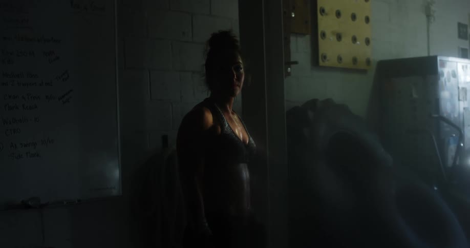 A female caucasian standing and breathing heavy in a gym