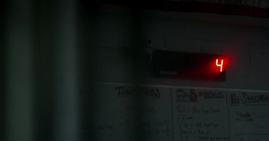 A digital display counting down above a white board with an exercise routine mapped out