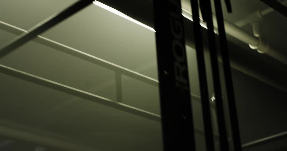 A metal handrail for a catwalk sits close to a ceiling light