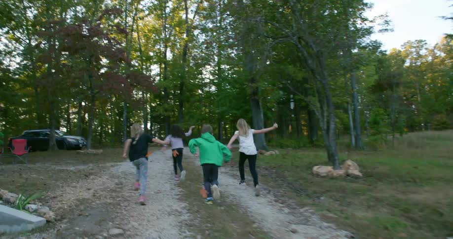 Children race towards the forest with flags