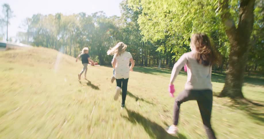 Kids race each other against yard the sun casting long shadows