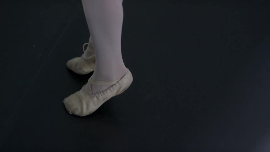A ballerina balancing on her toes in a dance studio