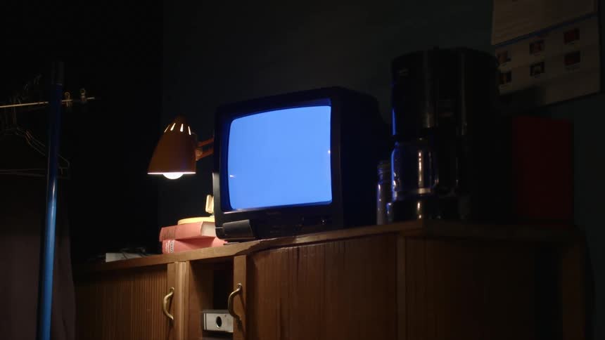 Television sits between a coffee maker and a desk lamp