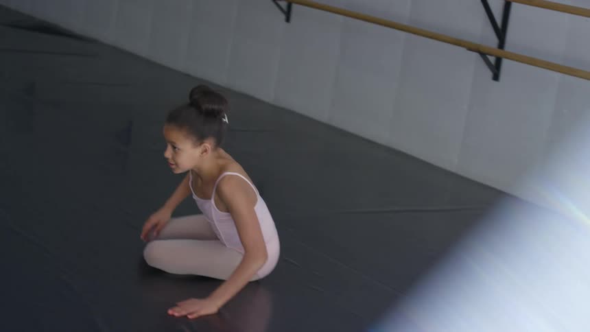 A ballerina dancing in a dance studio as her teacher observes