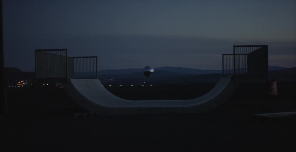 A silver ball floats above a skateboarding ramp