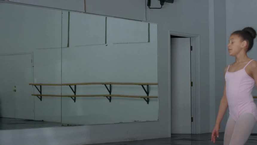A female child practicing ballet in a dance studio