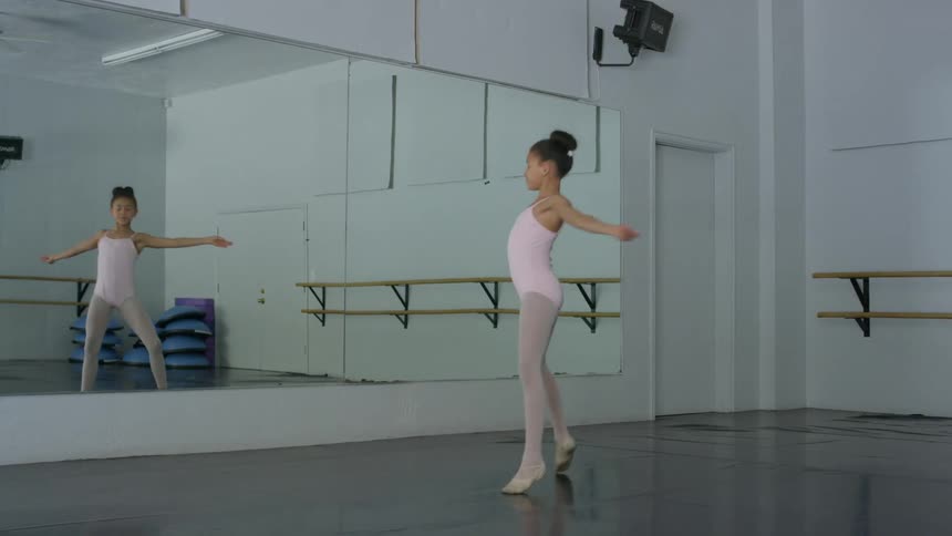 A young girl practices ballet and does a cartwheel