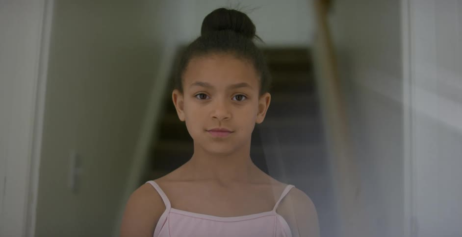 A young girl ballerina standing near stairs