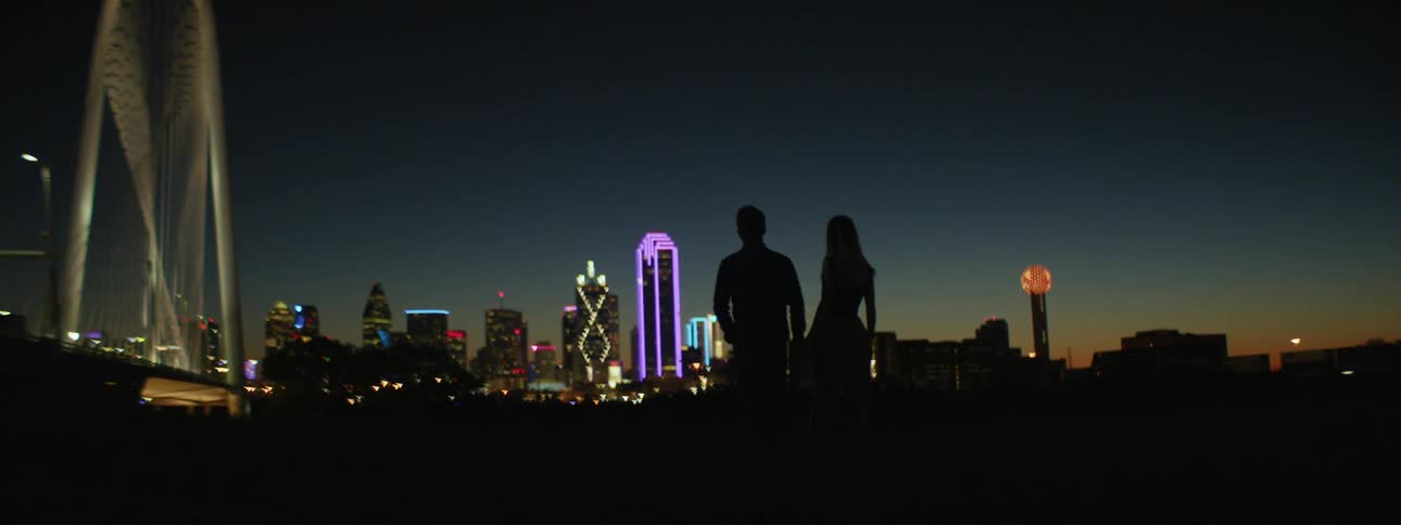 A man and woman are walking around at night